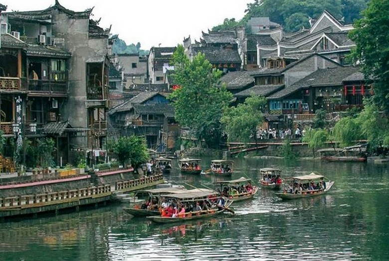 Du khách đi thuyền ngắm nhà sàn điếu cước lâu trên sông Đà Giang