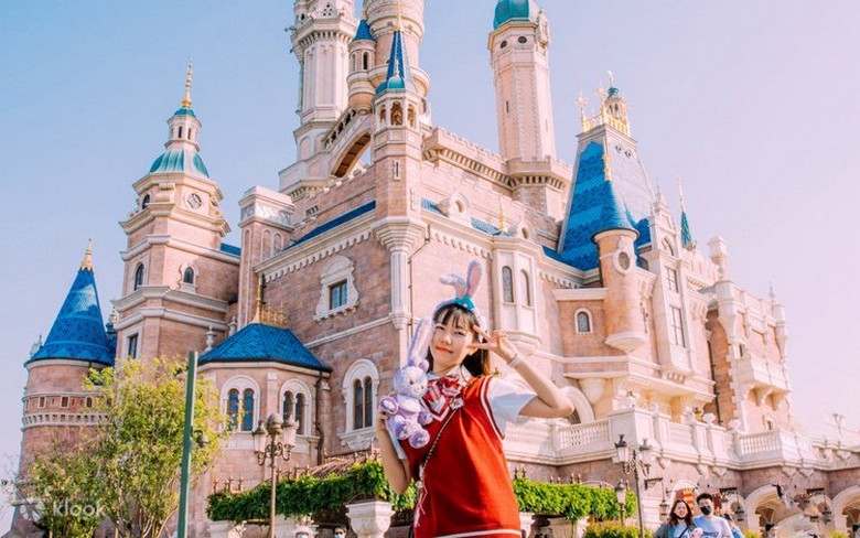 Gia đình có trẻ nhỏ chụp ảnh trước lâu đài Disneyland Thượng Hải