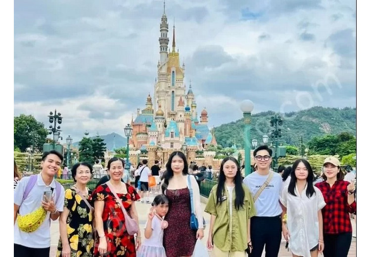  Đoàn khách gia đình Hà Nội cùng hướng dẫn viên tiếng Việt tại cổng Disneyland