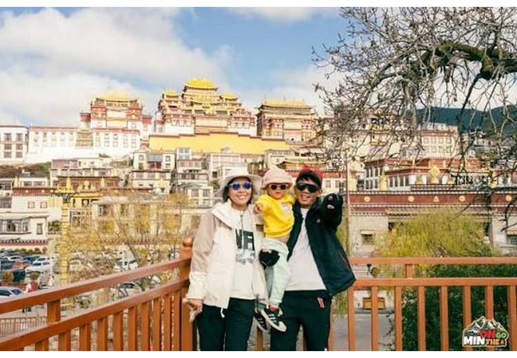 Du khách mặc áo phao dày đứng trước tu viện Tùng Tán Lâm ở Shangri-La