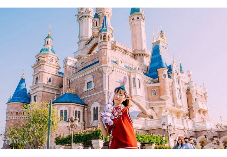 Gia đình có trẻ nhỏ chụp ảnh trước lâu đài Disneyland Thượng Hải