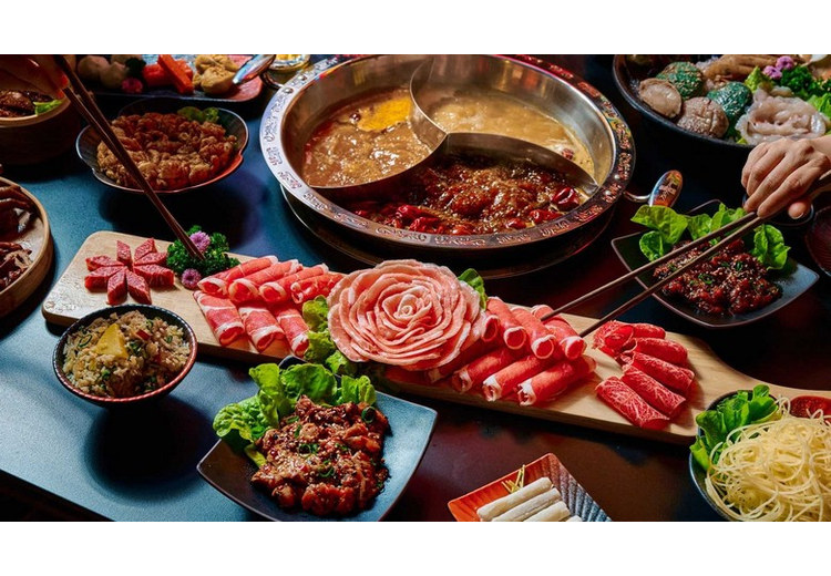 Một nồi lẩu Tứ Xuyên đỏ rực bốc khói với các loại nguyên liệu nhúng kèm