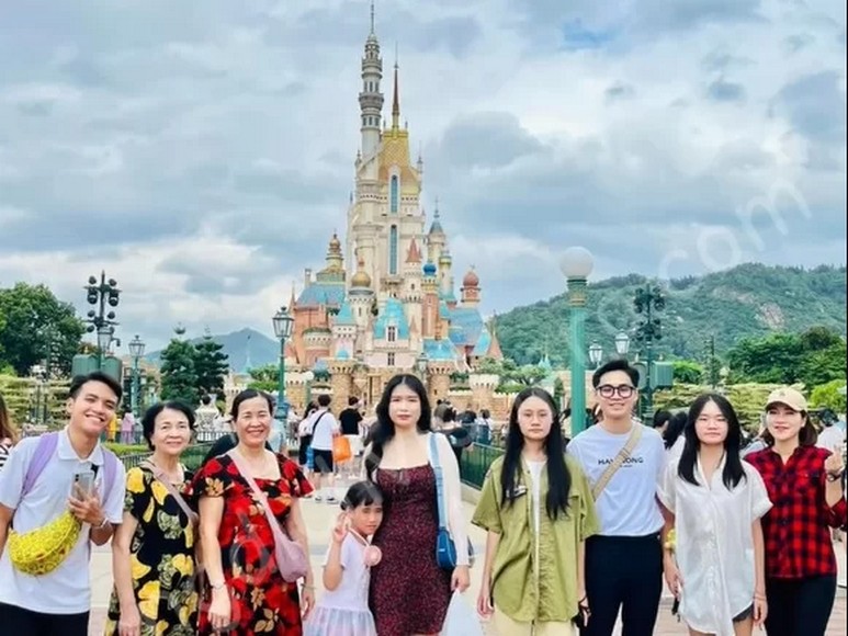  Đoàn khách gia đình Hà Nội cùng hướng dẫn viên tiếng Việt tại cổng Disneyland